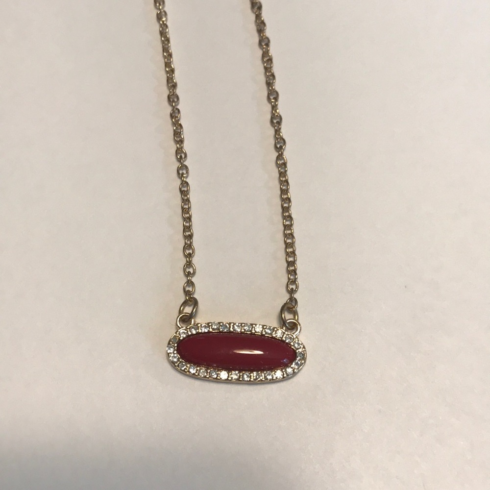 Gold chain necklace with red bedazzled gem
